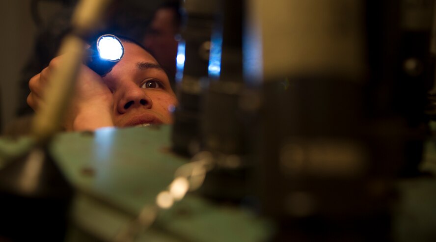 Airman 1st Class Salvador Gomez, 91st Missile Maintenance Squadron electro-mechanical team maintenance technician, uses a flashlight to check the surface of a cord before connecting it to a distribution box during training at Minot Air Force Base, N.D., April 09, 2014. The 91st Maintenance Group is the maintenance backbone of the 91st Missile Wing. The group was originally activated as the 91st Maintenance and Supply Group on November 10, 1948. Today, the group is responsible for providing maintenance and logistics support for the wing's ICBM fleet. (U.S. Air Force photo/Senior Airman Brittany Y. Auld)