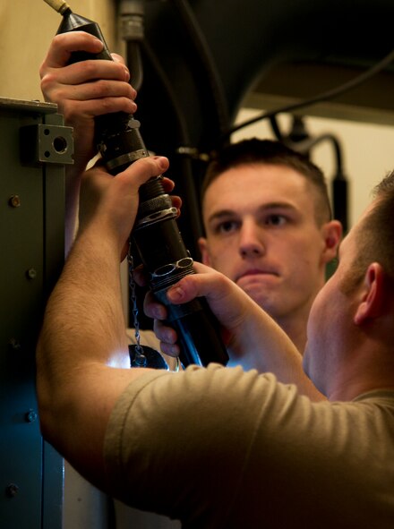 Electro-mechanical team maintenance technicians from the 91st Missile Maintenance Squadron connect a cord to the distribution box during training at Minot Air Force Base, N.D., April 09, 2014. The 91st Maintenance Group is responsible for providing maintenance and logistics support for the wing's ICBM fleet. (U.S. Air Force photo/Senior Airman Brittany Y. Auld)