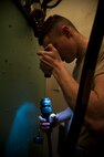 An electro-mechanical team maintenance technician from the 91st Missile Maintenance Squadron uses a flashlight to check the surface of a cord before connecting it to a distribution box during training at Minot Air Force Base, N.D., April 09, 2014. The 91st Maintenance Group is the maintenance backbone of the 91st Missile Wing. The group was originally activated as the 91st Maintenance and Supply Group on November 10, 1948. Today, the group is responsible for providing maintenance and logistics support for the wing's ICBM fleet. (U.S. Air Force photo/Senior Airman Brittany Y. Auld)