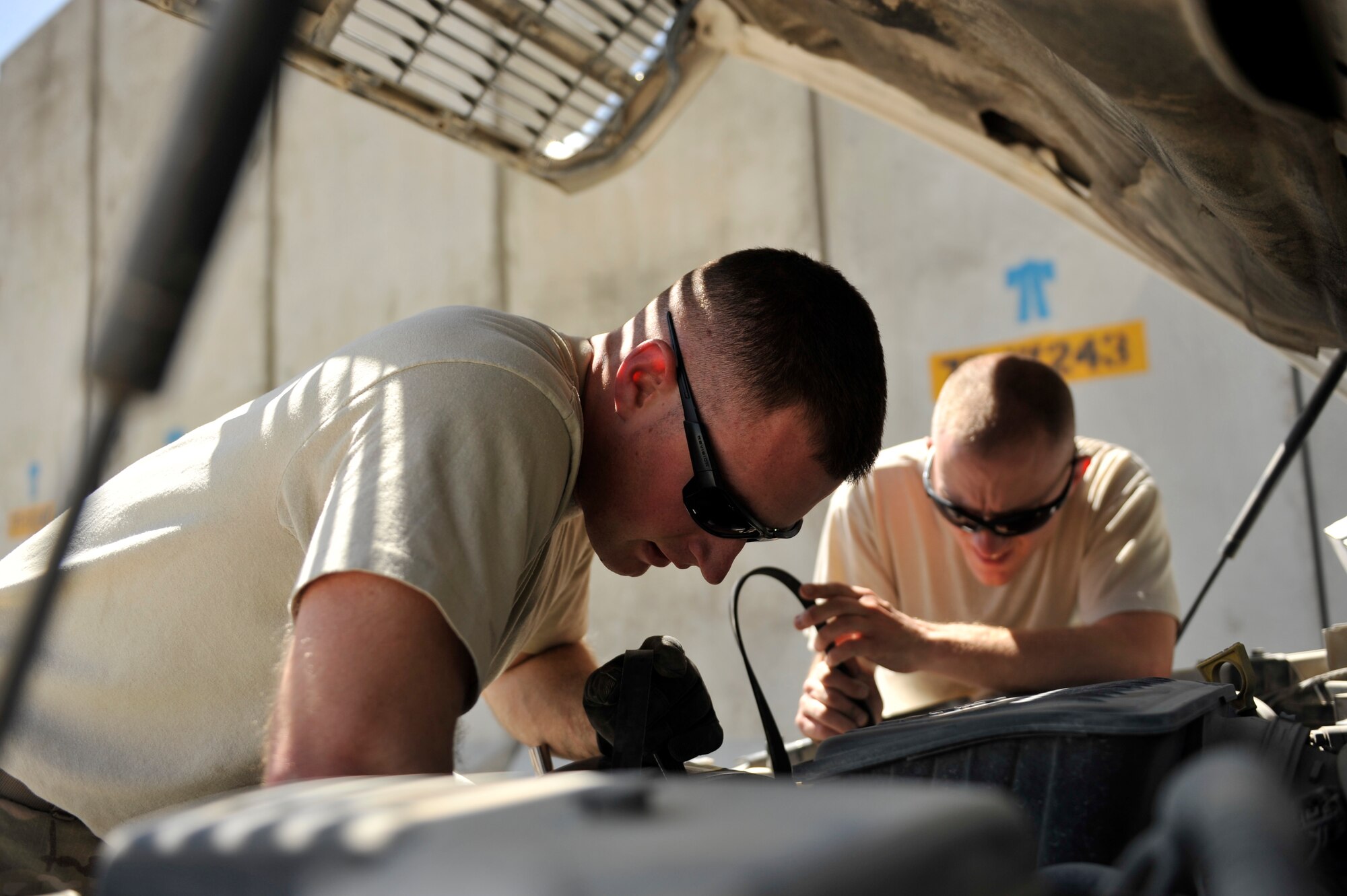 Senior Airman Joshua Jensen, left, and Tech. Sgt. James Groves, 455th Expeditionary Logistics Readiness Squadron vehicle maintenance technicians, change a pickup truck's serpentine belt at Bagram Air Field, Afghanistan April 26, 2014. Jensen, 22, from Port St. Lucie, Fla. is deployed from Holloman Air Force Base, N.M. Groves, 31, from Pearisburg, Va., is deployed from Spangdahlem Air Base, Germany. (U.S. Air Force photo by Maj. Brandon Lingle/Released)