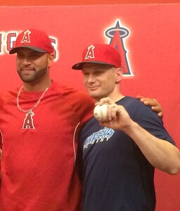U.S. Air Force Staff Sgt. Thomas Sherrill (right) stands with Albert Pujols of the Los Angeles Angels of Anaheim after catching Pujols' 500th career major league home run April 22, 2014, in Washington, D.C. Sherrill, a long-time Angels fan, moved into the left-centerfield bleachers at Nationals Park shortly before Pujols' milestone at bat. (Courtesy photo)