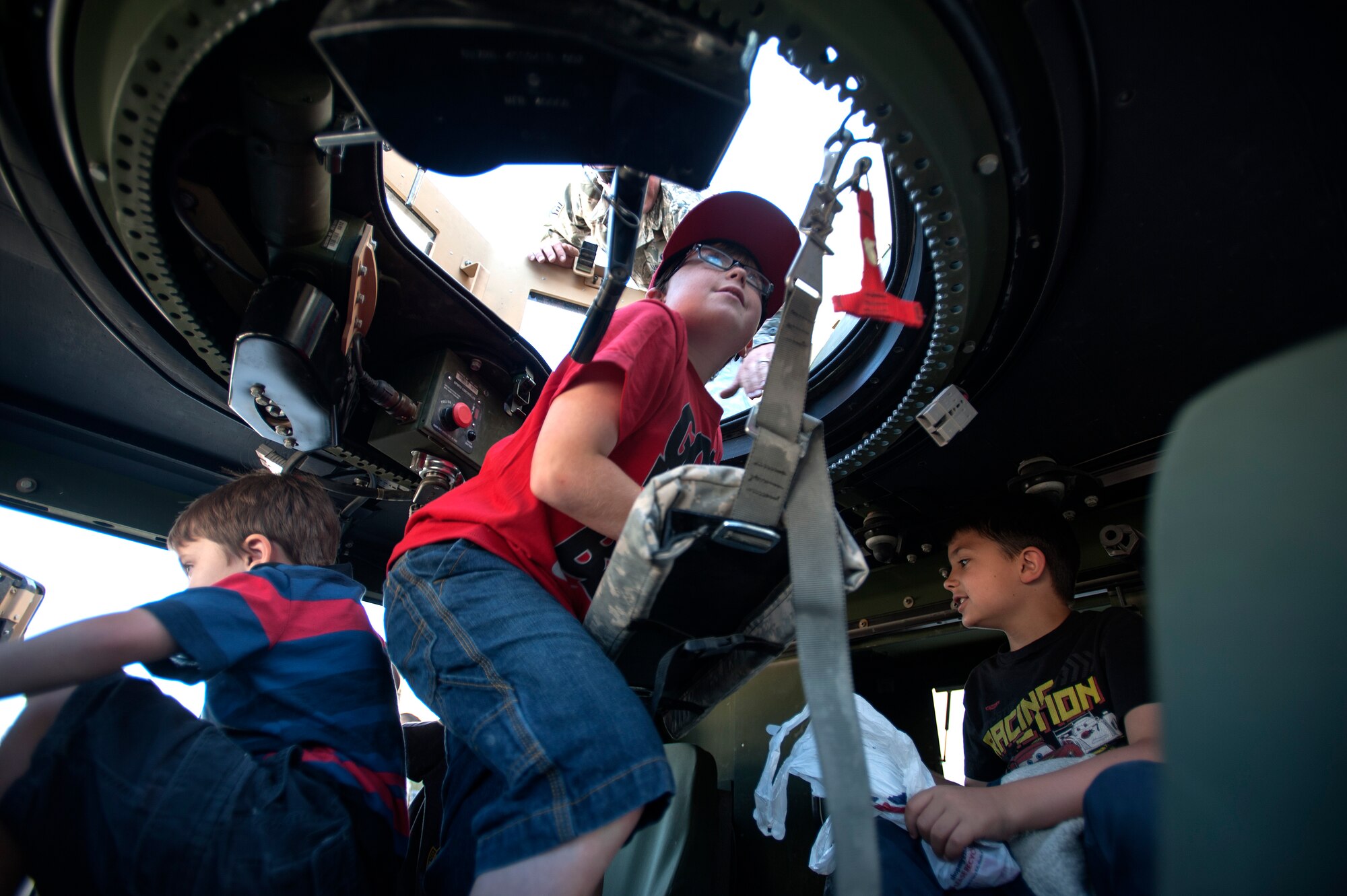 Dylan Barrett, 11, climbs onto the gunner's seat in a Humvee during a security forces static vehicle display as part of the Take Our Daughters and Sons to Work Day hosted on Creech Air Force Base, Nev., April 24, 2014. During the day's events the Creech Airmen and Family Readiness Center provided a plethora of events including demonstrations from the local fire deparement, work center tours, and a professional magician and DJ.