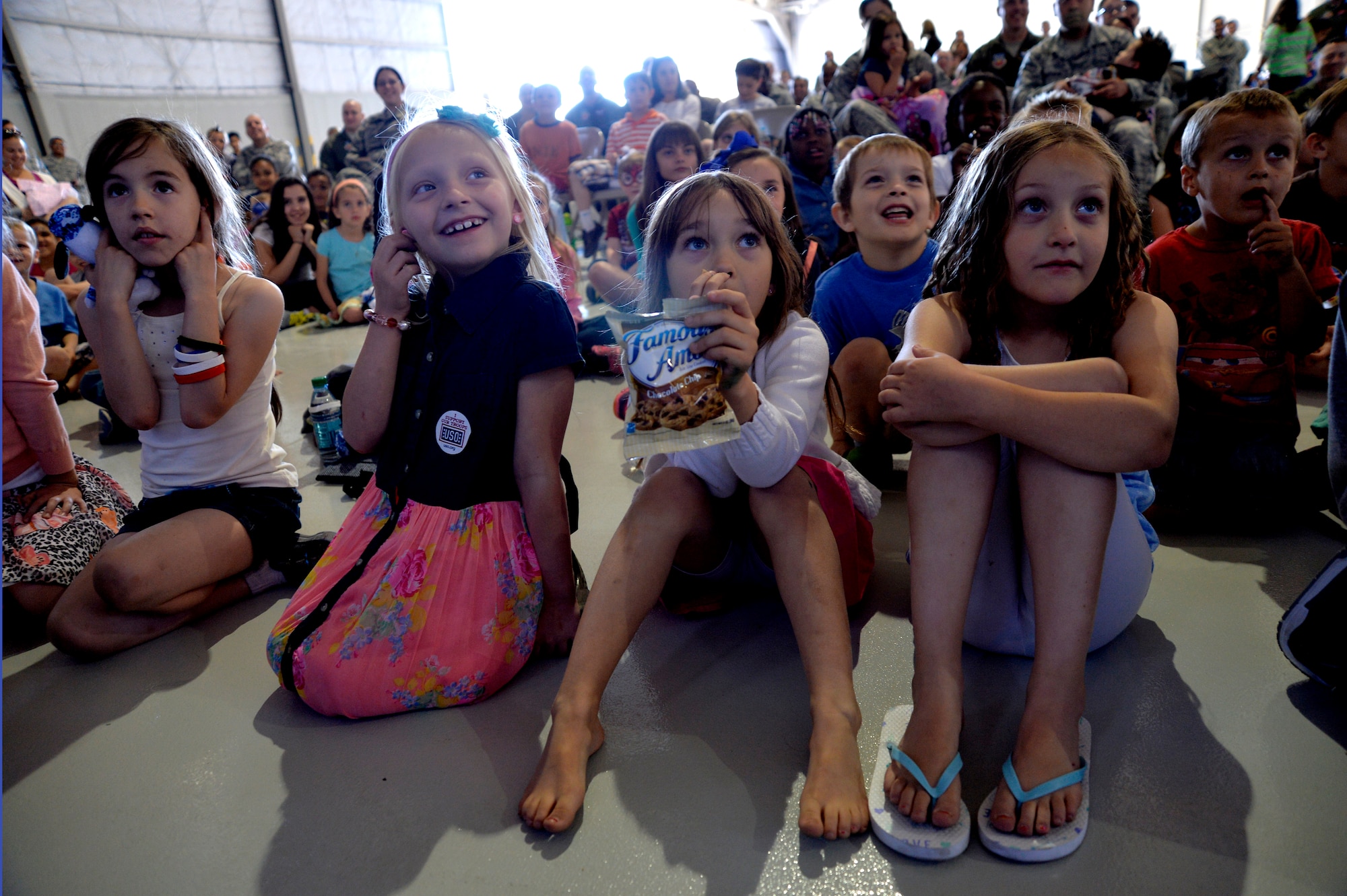 Children attending the Creech hosted Take Our Daughters and Sons to Work Day, sit and watch a magic show April 24, 2014 on Creech Air Force Base, Nev. During the day's events the Creech Airmen and Family Readiness Center provided a plethora of events including demonstrations from the local fire deparement, work center tours, and a professional magician and DJ.