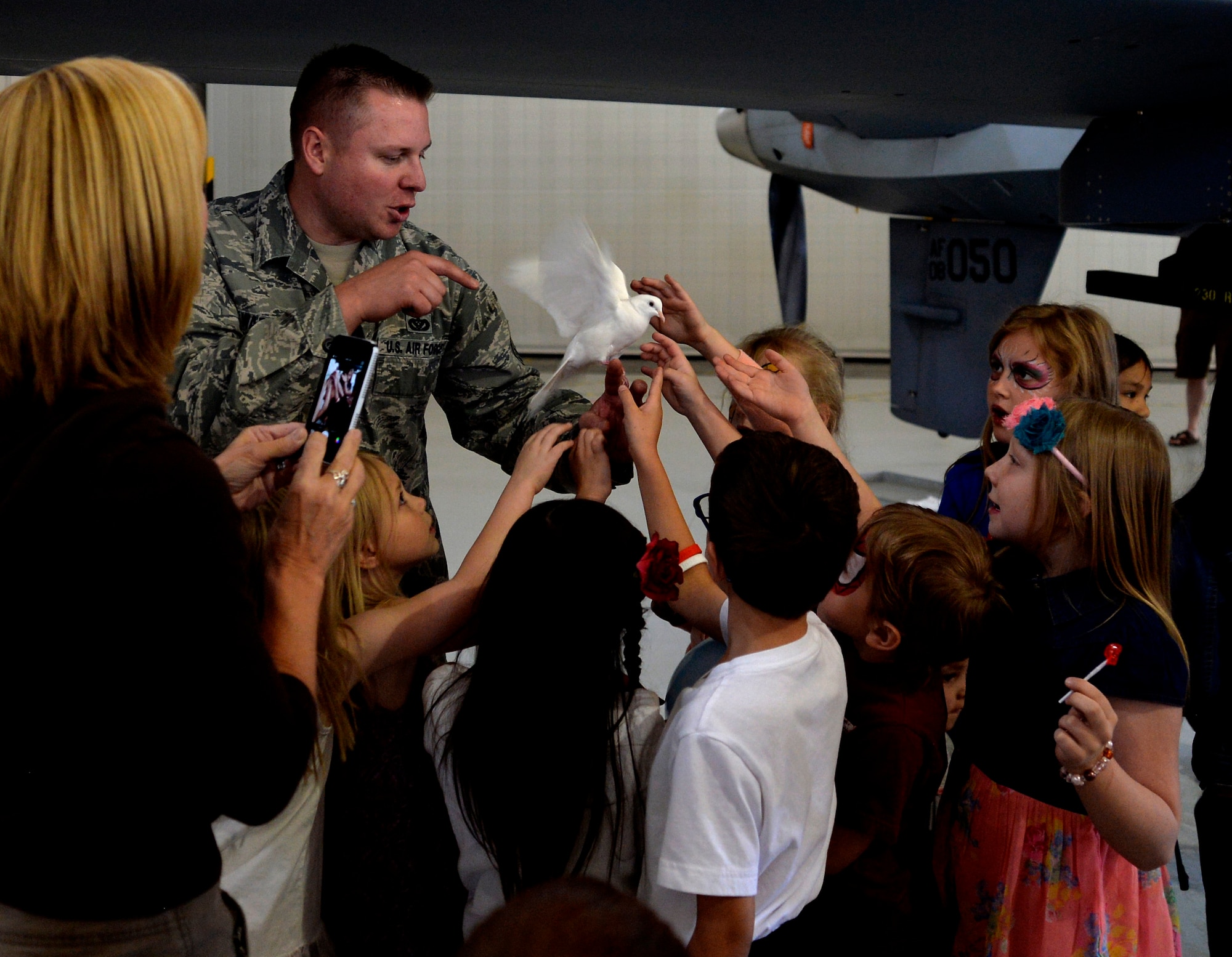 Tech. Sgt. Robert Warder, Creech Airmen and Family Readiness Center NCO in charge, shows children a dove used in a magic show during the Take Our Daughters and Sons to Work Day on Creech Air Force Base, Nev., April 24, 2014. 