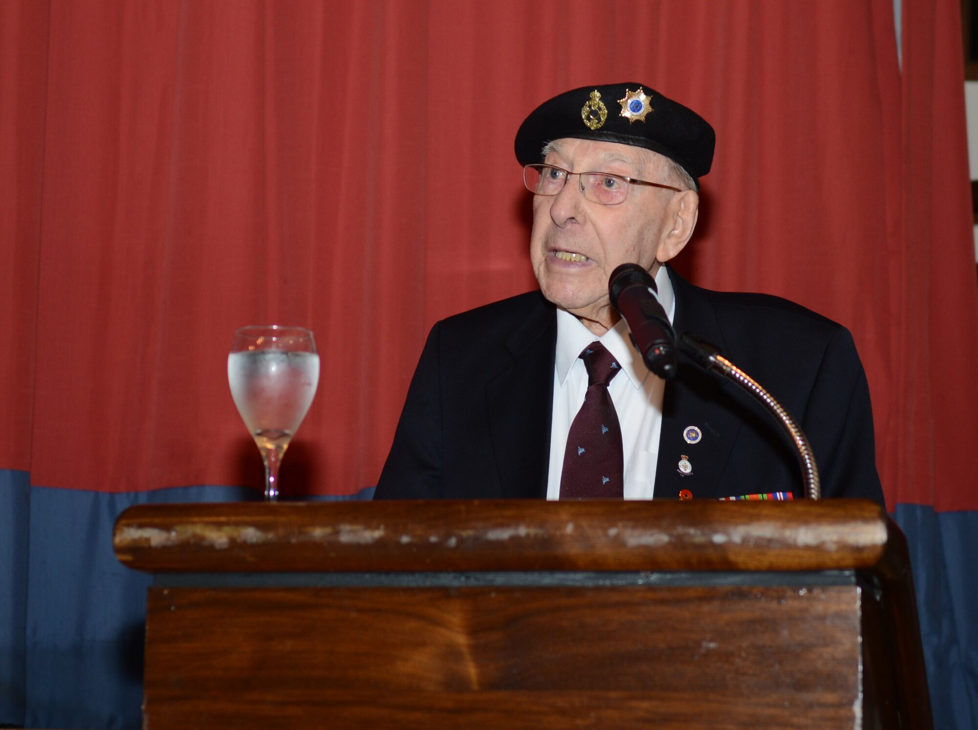 Harold Burgh, a former warrant officer in the Royal Electrical and Mechanical Engineers, speaks during a Holocaust Remembrance Luncheon April 28, 2014, on RAF Mildenhall, England. Burgh spoke about his time in the British Army and his experiences at the Bergen Belsen concentration camp in Germany following its liberation in 1945. (U.S. Air Force photo by Airman 1st Class Kyla Gifford/Released)