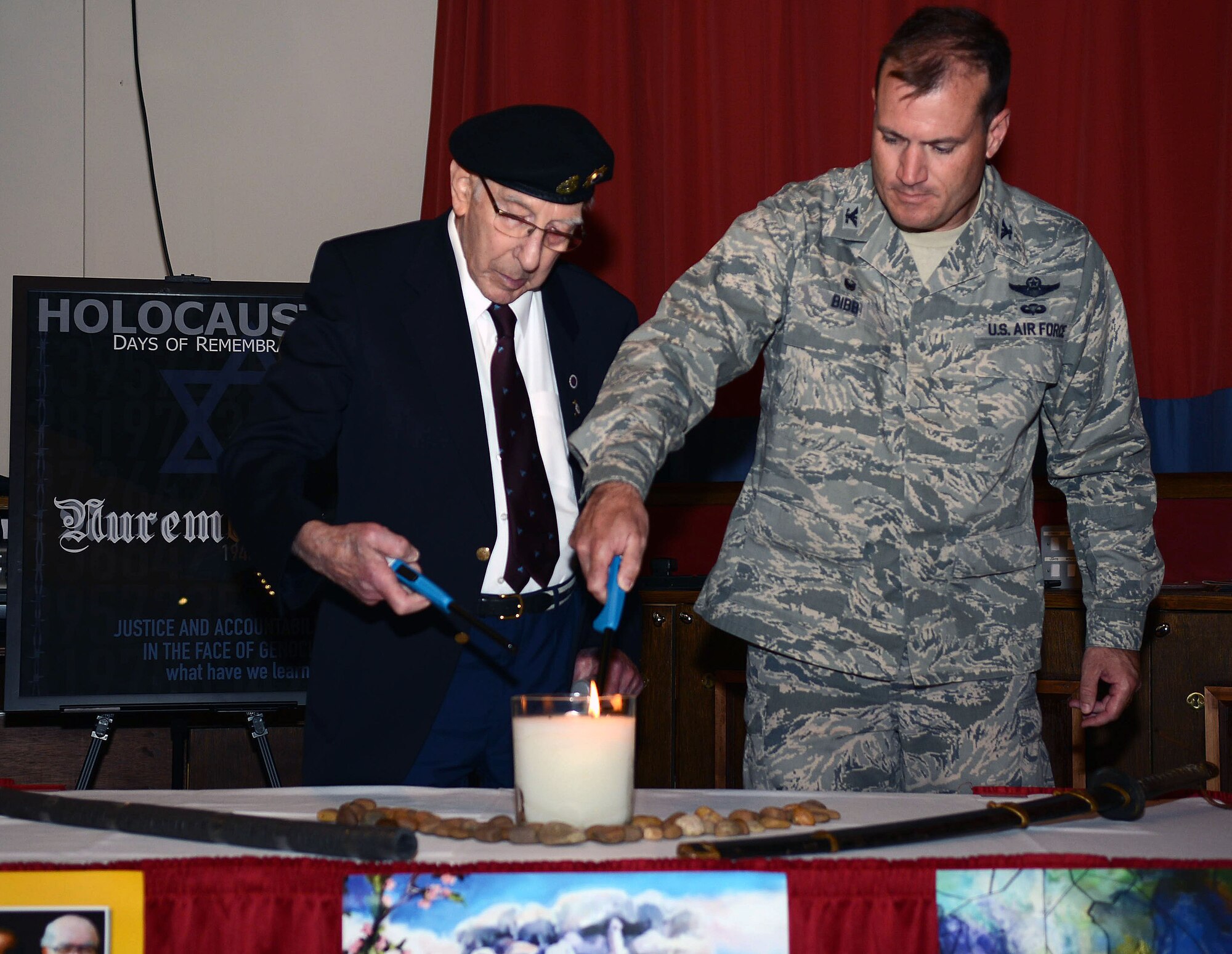 U.S. Air Force Col. Kenneth T. Bibb Jr., 100th Air Refueling Wing commander, lights a remembrance candle with Harold Burgh, a former warrant officer in the Royal Electrical and Mechanical Engineers, April 28, 2014, during a Holocaust Remembrance Luncheon on RAF Mildenhall, England. The luncheon featured a speech from Burgh about his time as part of the Royal Electrical and Mechanical Engineers in the British Army and his experiences at the Bergen Belsen concentration camp in Germany following its liberation in 1945. (U.S. Air Force photo by Airman 1st Class Kyla Gifford/Released)
