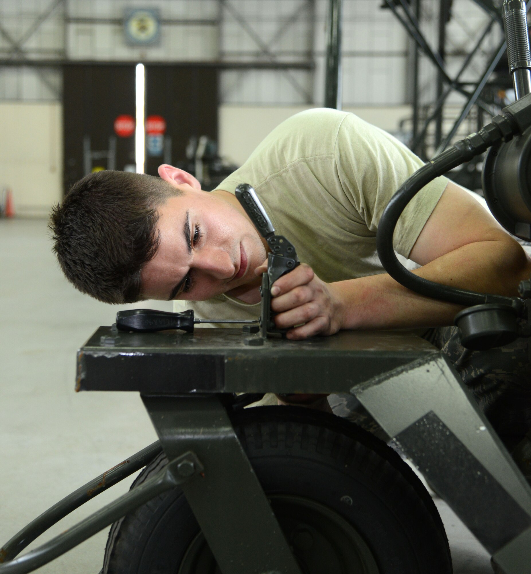 U.S. Air Force Staff Sgt. Cameron Frizzell, 100th Maintenance Squadron Aerospace Ground Equipment craftsman, fixes a hydraulic cart brake April 23, 2014, on RAF Mildenhall, England. The cart is used to fill aircraft with hydraulic fluid. (U.S. Air Force photo by Airman 1st Class Kelsey Waters/Released)