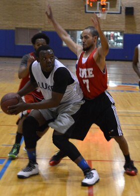 Patrick Paul, 56th Logistics Readiness Squadron, backs down a defender during the intramural basketball championship game April 14 against 56th Force Support Squadron at Luke Air Force Base. LRS defeated FSS 50-41. (U.S. Air Force photo/Senior Airman Devante Williams)
