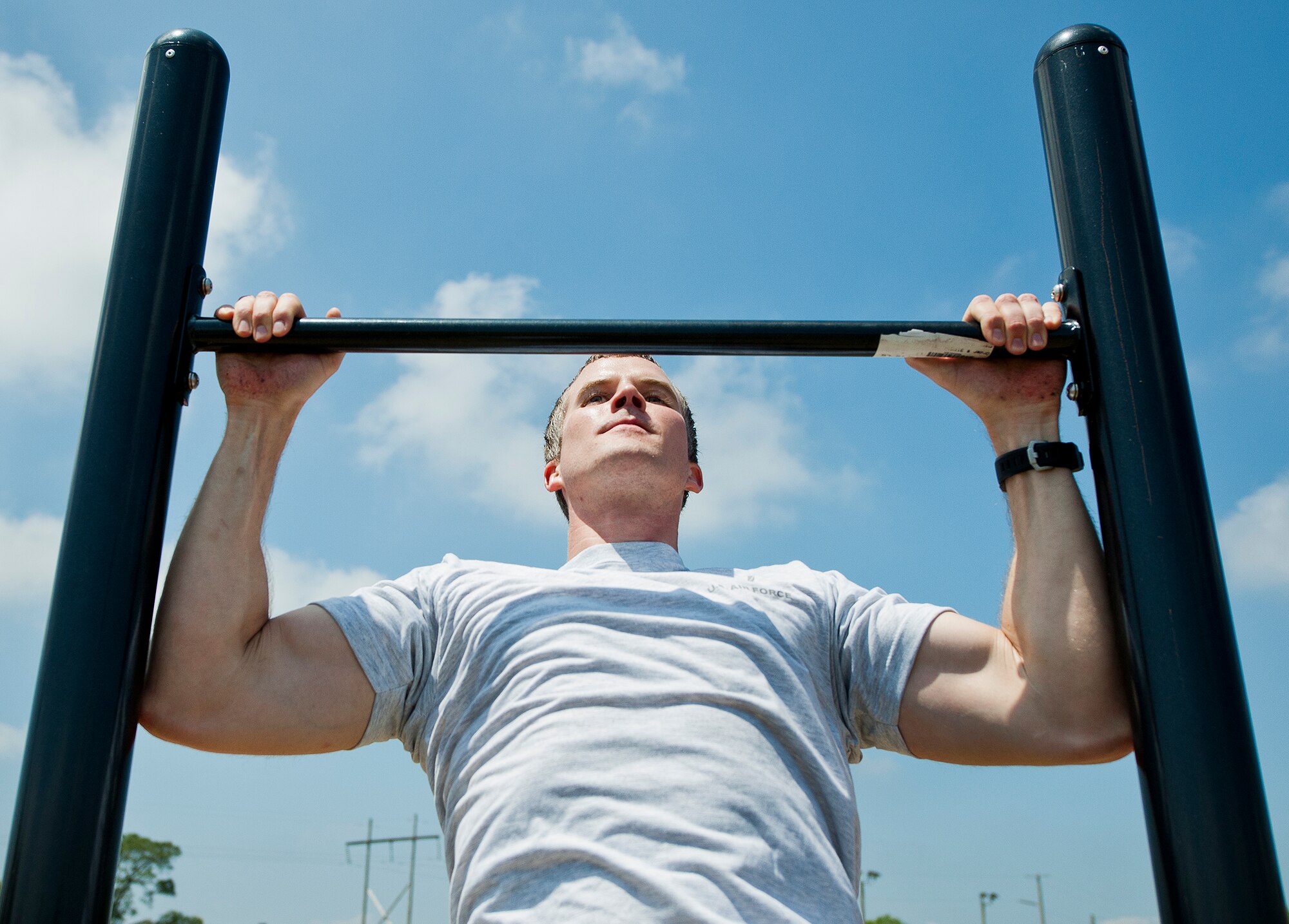 An Airman completes pull-ups at a strength challenge during the 96th Test Wing’s Wingman Day event April 24 at Eglin Air Force Base, Fla.  The morning events were for unit training then everyone converged on Foster Stadium for food and field day activities.  The theme of this year’s event was “Everyone’s a Mentor.”  (U.S. Air Force photo/Samuel King Jr.)