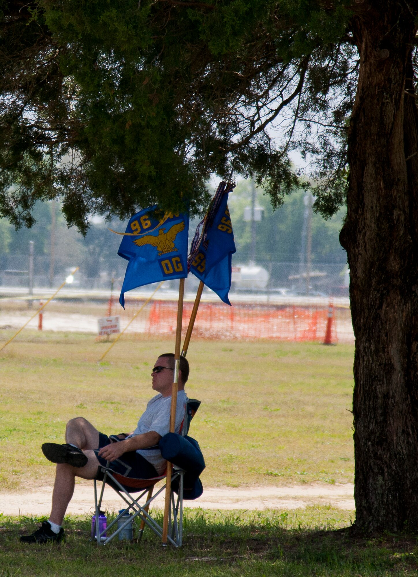 An Airman with the 96th Operations Group finds some shade underneath a tree during the 96th Test Wing’s Wingman Day event April 24 at Eglin Air Force Base, Fla.  The morning events were for unit training then everyone converged on Foster Stadium for food and field day activities.  The theme of this year’s event was “Everyone’s a Mentor.”  (U.S. Air Force photo/Samuel King Jr.)