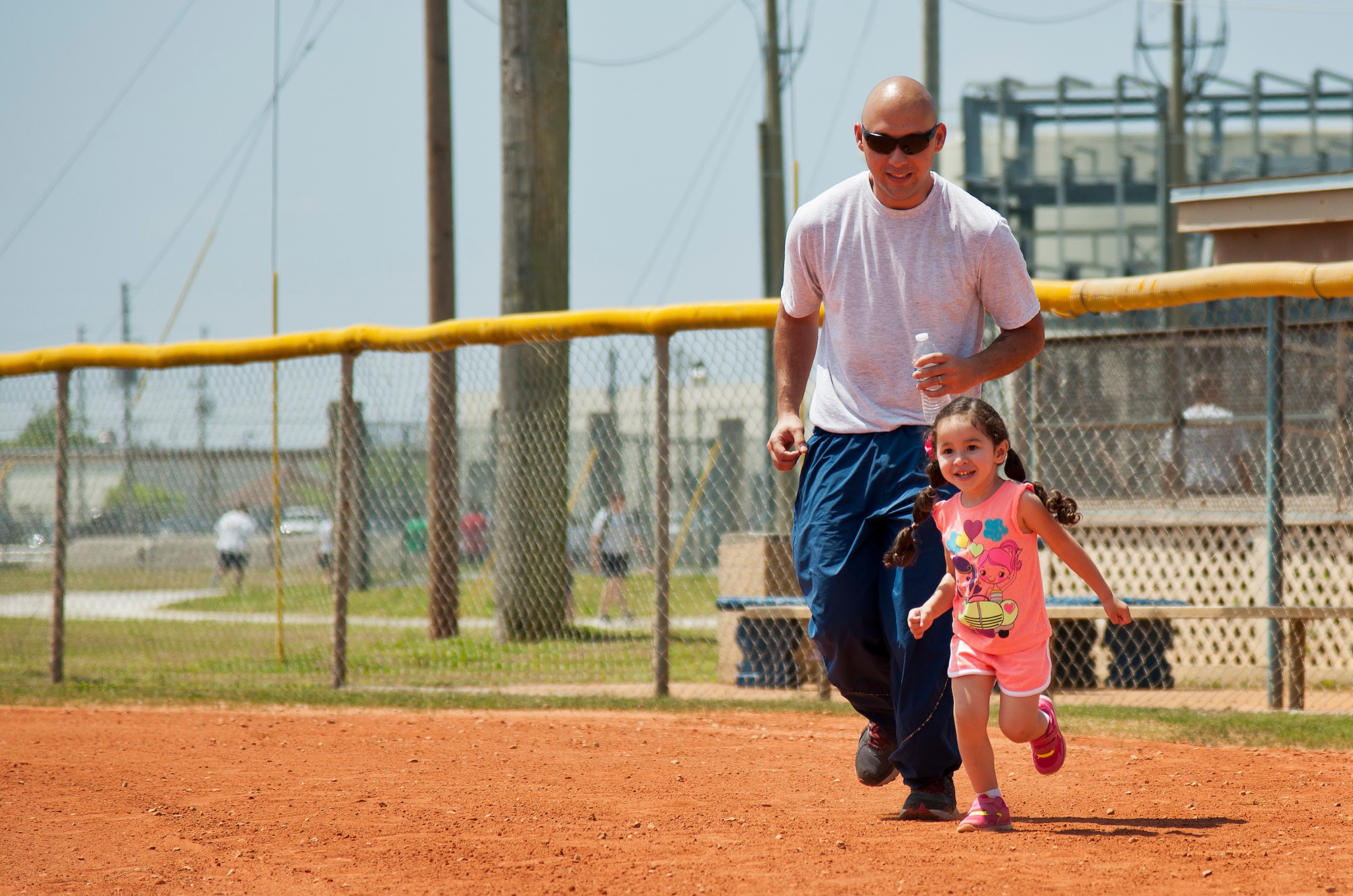 A 96th Test Wing Airman chases his daughter around the bases at Foster Stadium during the 96th Test Wing’s Wingman Day event April 24 at Eglin Air Force Base, Fla.  The morning events were for unit training then everyone converged on Foster Stadium for food and field day activities.  The theme of this year’s event was “Everyone’s a Mentor.”  (U.S. Air Force photo/Samuel King Jr.)