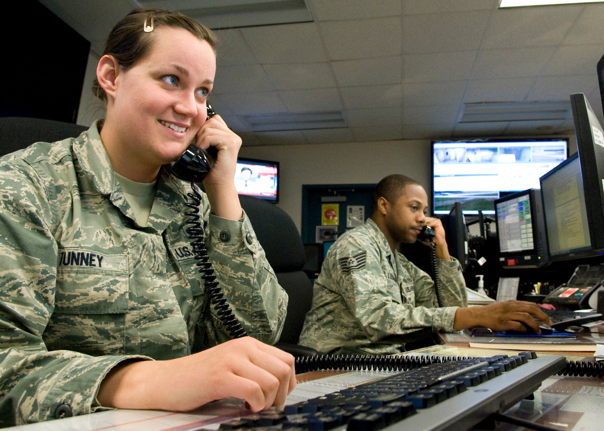 Airman 1st Class Maura Tunney, 436th Airlift Wing Command Post emergency actions controller, left, and Tech. Sgt. Andre Leonard, 436th AW/CP NCO in charge of training, take telephone calls April 22, 2014, inside the command post on Dover Air Force Base, Del. Throughout 2013, the 436th AW/CP was AMC’s workhorse, leading the safe launch and recovery of 4,866 missions. (U.S. Air Force photo/Airman 1st Class Zachary Cacicia)