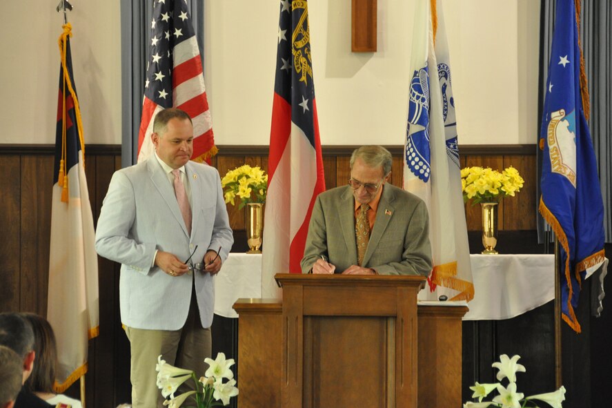 Col. (Ret) John Powers of the Dobbins Chapel Foundation, signs the historic Dobbins chapel over to Maj. Gen. James B. Butterworth, adjutant general of the Georgia National Guard during a Rededication and Transfer of Ownership Ceremony at the Gen. Lucius D. Clay National Guard Center April 27. The chapel was relocated from Dobbins Air Reserve Base to the Clay NGC in March 2013. (U.S. Air Force photo/James Branch)