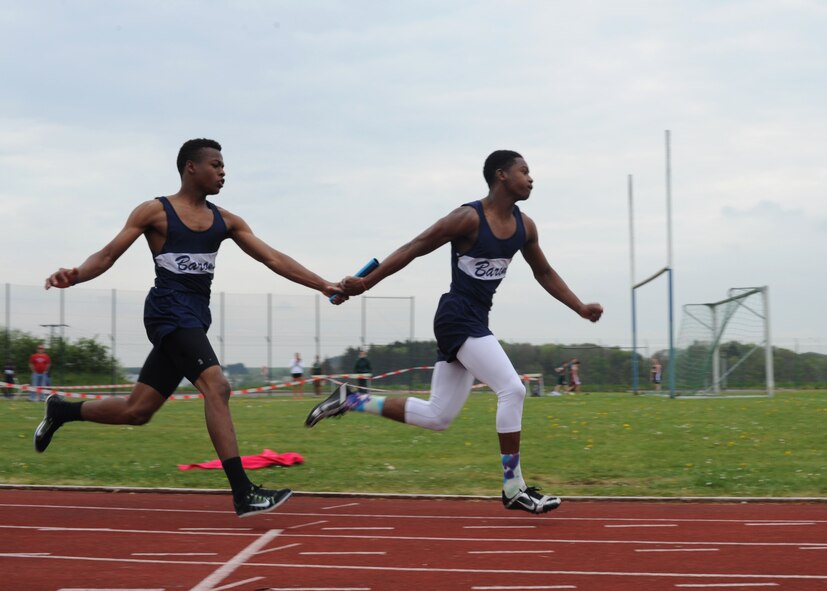 A Bitburg Middle High School athlete passes a baton to a teammate during the men’s 4x400 meter relay April 26, 2014, at the school track on Bitburg Base Annex, Germany.  The team won the race with a time of 3:43.69. (U.S. Air Force photo by Airman 1st Class Dylan Nuckolls/Released)