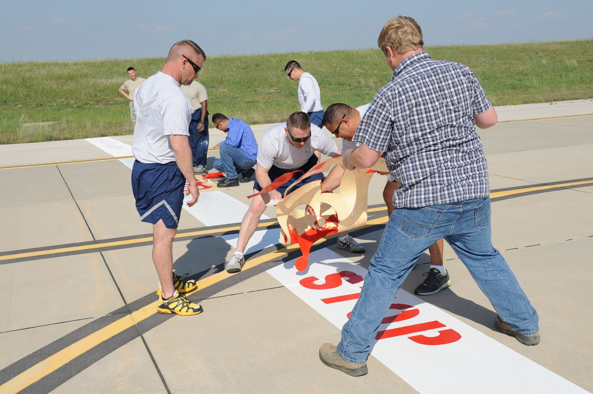 Members of the 39th Civil Engineer Squadron, paint new Controlled Movement Area markings with stencils April 22, 2014 at Incirlik Air Base, Turkey. The 39th CES members were all from multiple Air Force career fields within the squadron and worked jointly to accomplish making the flightline more efficient. (U.S. Air Force photo by Staff Sgt. Eboni Reams/Released)