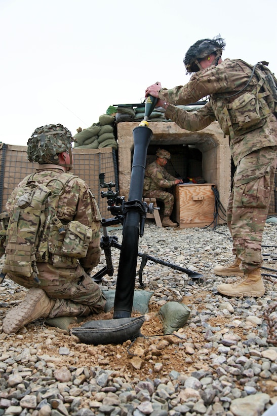 U.S. Army Spc. Shay Waite, right, prepares to fire an 81mm mortar round ...