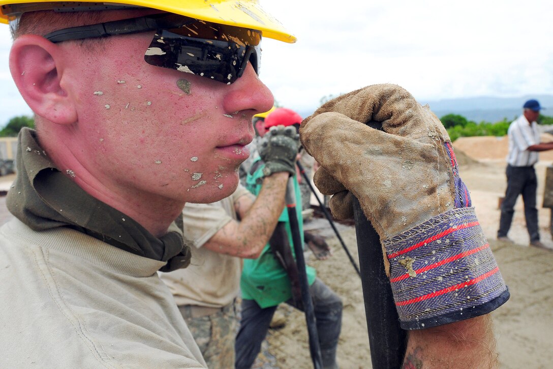 U.S. Army Spc. Mathew Bailey watches troops pour a foundation for a new school during Beyond the Horizon 2014 in Barahona, Dominican Republic, April 22, 2014. The mission  provides humanitarian assistance to Latin American countries, including medical care at no cost, and new schools and medical clinics to the improve quality of life for residents of participating countries. Bailey is a combat engineer assigned to the 665th Engineer Company.