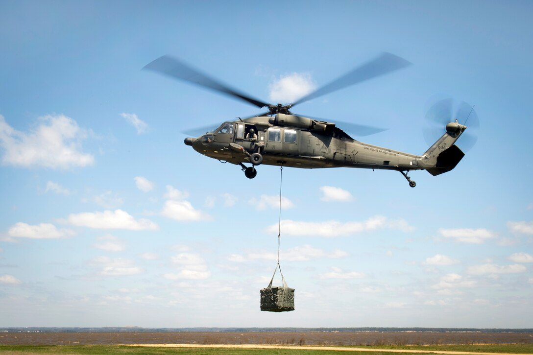 An Army UH-60 Black Hawk helicopter carries a load from a cargo pick up site during slingload training on Naval Annex Stump Neck in Indian Head, Md., April 23, 2014.