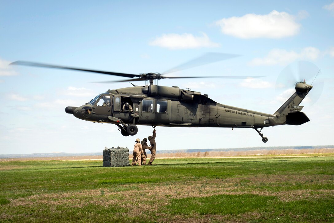 Marines hook cargo under an Army UH-60 Black Hawk helicopter during slingload training on Naval Annex Stump Neck in Indian Head, Md., April 23, 2014.