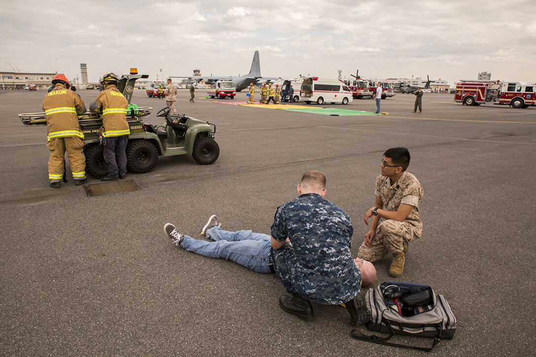 First responders from Robert M. Casey Medical and Dental Clinic, station Fire Department and the Provost Marshal’s Office tend to role-players during a mass casualty evacuation drill on the flight line aboard Marine Corps Air Station Iwakuni, Japan, April 2, 2014. The scenario simulated a propane tank explosion from a food vendor in a highly populated area.