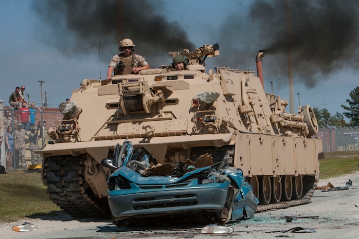 U.S. Marines Corporal Justin T. Glass (left), and Lance Cpl. Samuel W. Yan with 2nd Maintenance Battalion, 2nd Marine Logistics Group, prepare to crush a van with an M88 A-2 Tank Recovery Vehicle on family day on Camp Lejeune, N.C., April 24, 2014. The Marines showcased tactical vehicles and weapons to friends and family members to raise money for the Marine Corps ball. (U.S. Marine Corps photo by Lance Cpl. Desire M. Mora/Released)