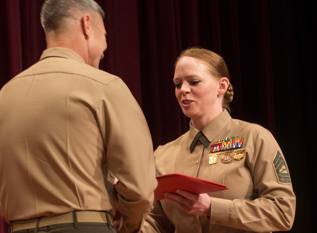 Master Sgt. Julia Watson, an instructor for the Marksmanship Training Unit at Marine Forces Reserve New Orleans, accepts her silver medal in the Competition-In-Arms Western Divisional individual pistol competition at the base theatre of Marine Corps Base Camp Pendleton, Calif., March 7. With the silver medal, Watson secured the final eight points she needed to become a distinguished pistol shooter.