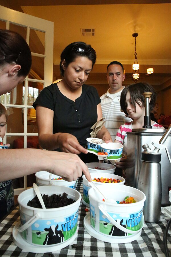 Ana Medina, Lyman Park resident, puts toppings on her ice cream during a block party at the Lincoln Military Housing Family Center on April 22, 2014. More than 400 people attended the event which was one of six 2014 Quantico community block parties.