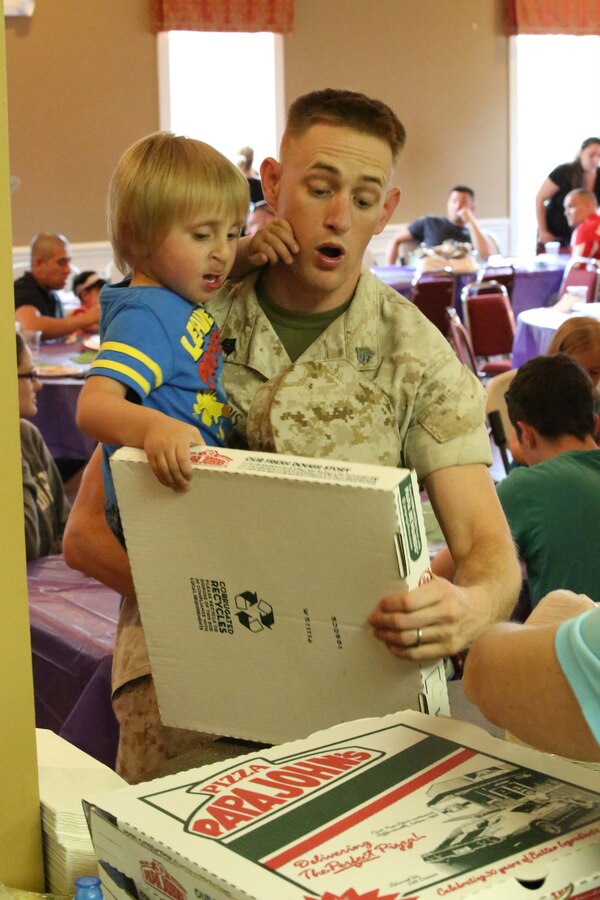 Lukas, 3, almost drops a box of pizza, while his dad, Sgt. Michael Morris, helps him at the Lincoln Military Housing Family Center on April 22, 2014. The Lincoln Military Housing served pizza and ice cream to the residents of Lyman Park, a Marine Corps Base Quantico community, during one of six Quantico community block parties this year. 