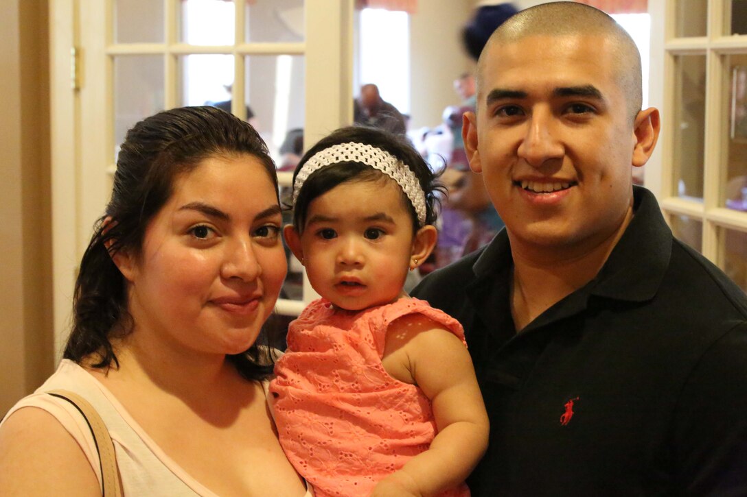 Marcelo Saldivarortiz, his wife Joanna, and their daughter Christie, 1, pose for a photo at a Lyman Park community block party at the Lincoln Military Housing Family Center April 22, 2014. More than 400 people attended the event which was one of six 2014 Quantico community block parties.