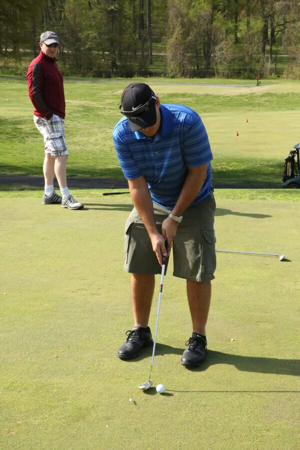 Frank Brewster, golfer, putts out during the Putt for the Paw Golf Tournament at the Medal of Honor Golf Course on April 25, 2014. The event was hosted by the golf course and the Washington, D.C., chapter of Pets for Vets organization. 