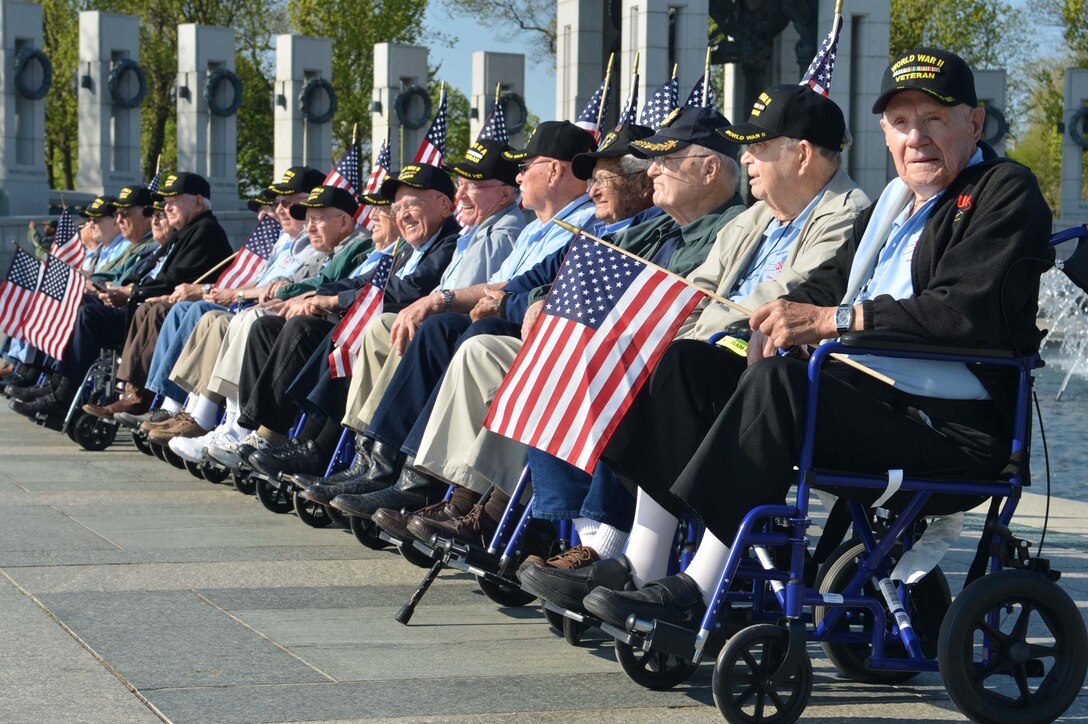 World War II veterans sit back and enjoy each other’s company as a crowd of military supporters take their photos during an Honor Flight event  at the World War II Memorial in Washington, D.C., on April 26, 2014. There were 16 World War II veterans that were a part of an Honor Flight from Austin, Texas. (Marine Corps Photo by Cpl. Antwaun Jefferson)