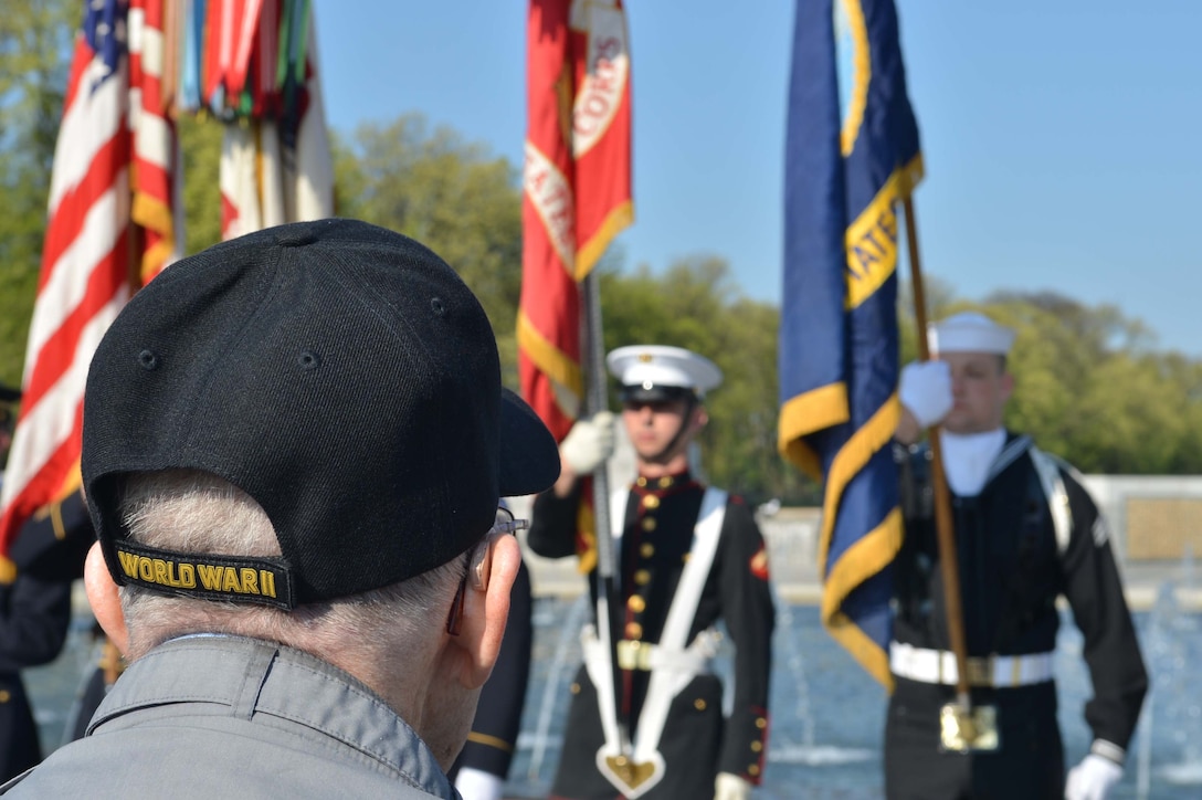 Retired Army Air Corps Sgt. James White, World War II veteran, looks on at the Joint Service Color Guard present the colors during a ceremony at the World War II Memorial in Washington, D.C., on April 26, 2014. The World War II veterans were from all branches of the military. (Marine Corps Photo by Cpl. Antwaun Jefferson)
