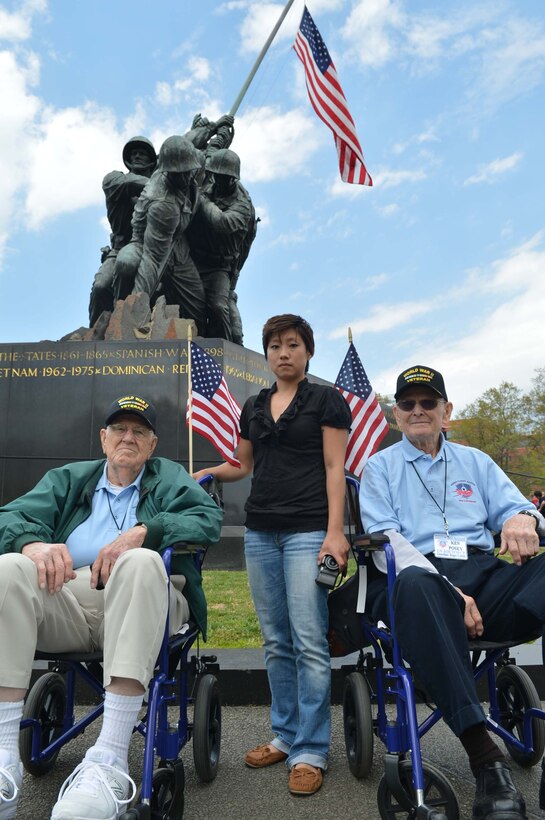 Cpl. Sara Gore, one of the guardians for the Austin, Texas, Honor Flight, helps guide two World War II veterans, retired Army Air Corps Sgts. Wade H. Armstrong and Ken Posey at the Marine Corps War Memorial in Arlington, Va., on  April 26, 2014. Every veteran was assigned a guardian who stuck by them the entire two-day trip to help with anything the veteran needed. (Marine Corps Photo by Cpl. Antwaun Jefferson)