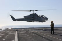 A U.S. Navy Sailor observes as an AH-1W Super Cobra with Marine Light Attack Helicopter Squadron (HMLA) 269 prepares to land aboard the USS New York (LPD 21) flight deck off the shore of Jacksonville, Fla., April 26, 2014, during the ship’s departure to South Florida. Marines and Sailors from HMLA-269, Marine Corps Air Station New River, N.C., 2nd Assault Amphibian Battalion, and 2nd Battalion, 6th Marine Regiment, 2nd Marine Division, Marine Corps Base Camp Lejeune, N.C., embarked aboard the USS New York and set sail to South Florida to partake in the 24th annual Fleet Week in Port Everglades, South Florida’s annual celebration of maritime forces. (U.S. Marine Corps photo by Sgt. Alicia R. Leaders/Released)