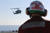Cpl. Gary L. Holthus II, native of Denver, Colo., and airframes mechanic with Marine Light Attack Helicopter Squadron (HMLA) 269, watches as AH-1W Super Cobra with HMLA-269 prepares to land aboard the USS New York (LPD 21) flight deck off the shore of Jacksonville, Fla., April 26, 2014, during the ship’s departure to South Florida. Marines and Sailors from HMLA-269, Marine Corps Air Station New River, N.C., 2nd Assault Amphibian Battalion, and 2nd Battalion, 6th Marine Regiment, 2nd Marine Division, Marine Corps Base Camp Lejeune, N.C., embarked aboard the USS New York and set sail to South Florida to partake in the 24th annual Fleet Week in Port Everglades, South Florida’s annual celebration of maritime forces. (U.S. Marine Corps photo by Sgt. Alicia R. Leaders/Released)