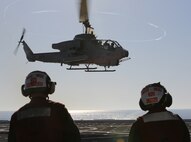 Cpl. Gary L. Holthus II, native of Denver, Colo., and airframes mechanic with Marine Light Attack Helicopter Squadron (HMLA) 269, and Lance Cpl. Brian W. Emma, native of Chicago, Ill., airframes mechanic with HMLA-269, watch as an AH-1W Super Cobra with HMLA-269 takes off the flight deck of the USS New York (LPD 21) during flight operations off the shore of Jacksonville, Fla., April 26, 2014, during the ship’s departure to South Florida. Marines and Sailors from HMLA-269, Marine Corps Air Station New River, N.C., 2nd Assault Amphibian Battalion, and 2nd Battalion, 6th Marine Regiment, 2nd Marine Division, Marine Corps Base Camp Lejeune, N.C., embarked aboard the USS New York and set sail to South Florida to partake in the 24th annual Fleet Week in Port Everglades, South Florida’s annual celebration of maritime forces. (U.S. Marine Corps photo by Sgt. Alicia R. Leaders/Released)