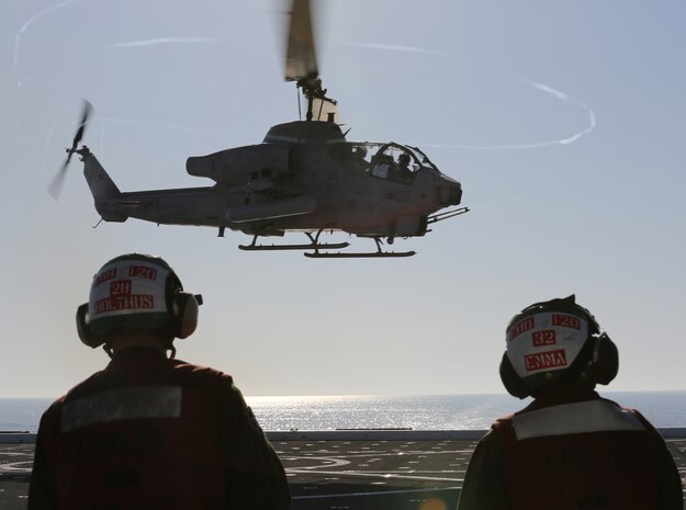 Cpl. Gary L. Holthus II, native of Denver, Colo., and airframes mechanic with Marine Light Attack Helicopter Squadron (HMLA) 269, and Lance Cpl. Brian W. Emma, native of Chicago, Ill., airframes mechanic with HMLA-269, watch as an AH-1W Super Cobra with HMLA-269 takes off the flight deck of the USS New York (LPD 21) during flight operations off the shore of Jacksonville, Fla., April 26, 2014, during the ship’s departure to South Florida. Marines and Sailors from HMLA-269, Marine Corps Air Station New River, N.C., 2nd Assault Amphibian Battalion, and 2nd Battalion, 6th Marine Regiment, 2nd Marine Division, Marine Corps Base Camp Lejeune, N.C., embarked aboard the USS New York and set sail to South Florida to partake in the 24th annual Fleet Week in Port Everglades, South Florida’s annual celebration of maritime forces. (U.S. Marine Corps photo by Sgt. Alicia R. Leaders/Released)