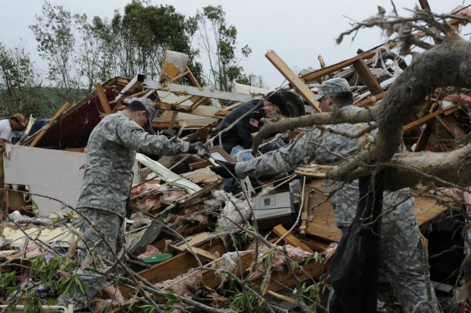 Arkansas National Guard members from the Conway based Special Troops Battalion, 39th Infantry Brigade Combat Team assist a family in Mayflower, Arkansas, salvage precious heirlooms amongst the debris April 28, 2014. Guardsmen were called to respond to their fellow neighbors in need after a tornado devastated communities in central Arkansas April 27, 2014. 