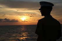 Lance Cpl. Ethan C. Hogeland, native of Fayetteville, N.C., and amphibious assault vehicle crewman with 2nd Assault Amphibian Battalion, 2nd Marine Division, Marine Corps Base Camp Lejeune, N.C., watches the sunrise on the flight deck in preparation for manning the rails as the USS New York (LPD 21) sails into South Florida for Fleet Week Port Everglades 2014, April 28. Approximately 120 Marines from 2nd AAV Bn., 2nd Battalion, 6th Marine Regiment, 2nd Marine Division, Marine Corps Base Camp Lejeune, N.C., and Marine Light Attack Helicopter Squadron (HMLA) 269, Marine Corps Air Station New River, N.C., are participating in the 24th Annual Fleet Week in Port Everglades; South Florida’s annual celebration of maritime forces. (U.S. Marine Corps photo by Sgt. Alicia R. Leaders/Released)