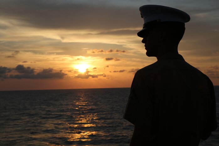 Lance Cpl. Ethan C. Hogeland, native of Fayetteville, N.C., and amphibious assault vehicle crewman with 2nd Assault Amphibian Battalion, 2nd Marine Division, Marine Corps Base Camp Lejeune, N.C., watches the sunrise on the flight deck in preparation for manning the rails as the USS New York (LPD 21) sails into South Florida for Fleet Week Port Everglades 2014, April 28. Approximately 120 Marines from 2nd AAV Bn., 2nd Battalion, 6th Marine Regiment, 2nd Marine Division, Marine Corps Base Camp Lejeune, N.C., and Marine Light Attack Helicopter Squadron (HMLA) 269, Marine Corps Air Station New River, N.C., are participating in the 24th Annual Fleet Week in Port Everglades; South Florida’s annual celebration of maritime forces. (U.S. Marine Corps photo by Sgt. Alicia R. Leaders/Released)