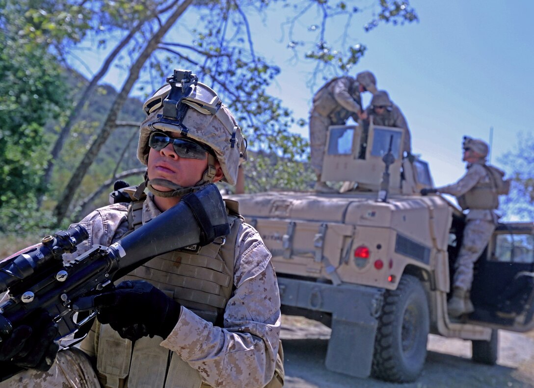 A Marine with Combat Logistics Battalion I provides security for his fellow Marines aboard Camp Pendleton, Calif., April 15, 2014. The Marines stripped the vehicle of any serialized equipment and weapons when responding to a mock Improvised Explosive Device attack for the Counter-IED, Defeat the Device training Program. The program gave to Marines the abilities to spot and respond effectively to an IED in a deployed environment.
