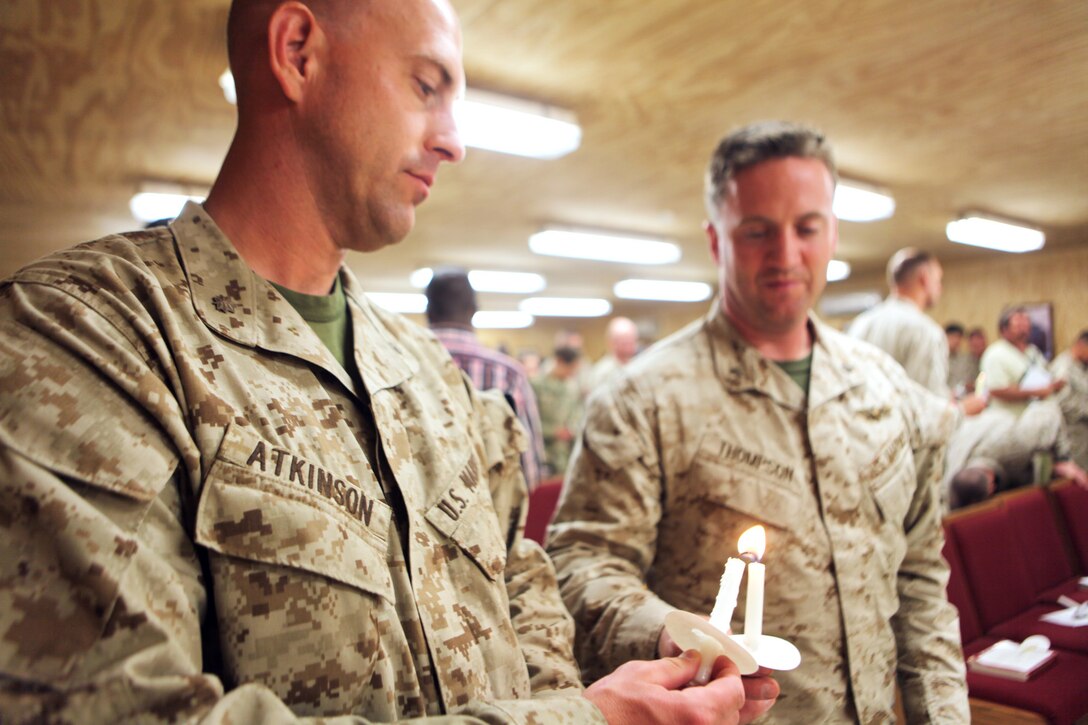 Service members light each other's candles during Easter Vigil Mass aboard Camp Leatherneck, Helmand province, Afghanistan, April 19, 2014. Throughout Holy Week there were many opportunities for people of the Christian faith to meet and share a fellowship with their fellow believers. (U.S. Marine Corps photo by Cpl. Joshua Young)
