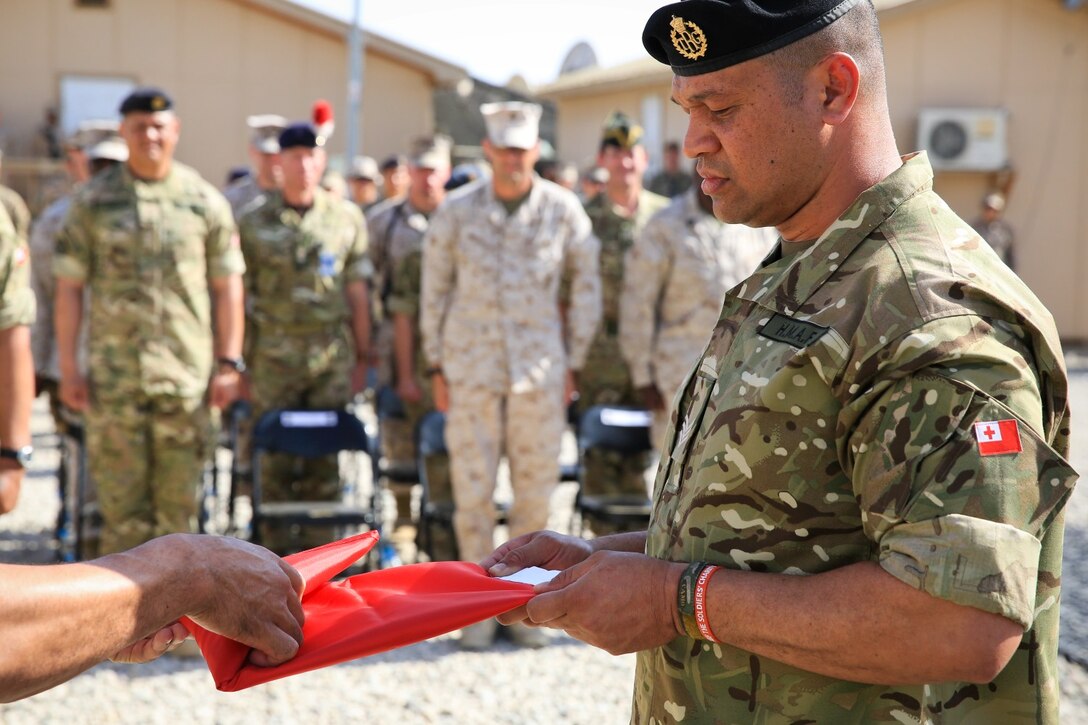 A Royal Tongan Marines assigned to Tranche 7, the seventh and final rotational contingent of Royal Tongan Marines to Afghanistan, holds his nation's flag while it's folded in a ceremony aboard Camp Leatherneck, Helmand province, Afghanistan, April 28, 2014. The lowering of the flag symbolizes the end of the Kingdom of Tonga's participation in Operation Enduring Freedom and return to their homeland.
(Official U.S. Marine Corps photo by Lance Cpl. Darien J. Bjorndal, Marine Expeditionary Brigade Afghanistan/ Released)