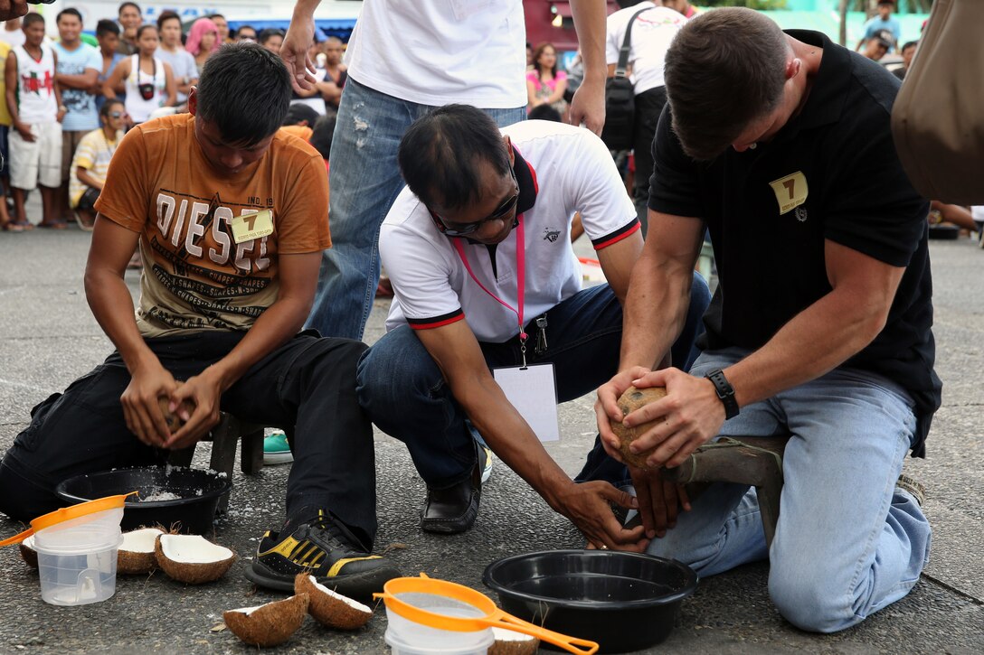 Philippine Army Pfc. Emman Bronzal, left, and U.S. Marine Lance Cpl. Michael Cameron carve coconut meat April 24 during the Kudkod-Paga, Turo-Gata at the Magayan Festival in Legazpi City, Albay Province, Philippines. Kudkod-Paga, Turo-Gata means “coconut milk extraction contest,” and is a contest during the annual festival to determine who can produce the most milk in a given time. Bronzal and Cameron are part of Exercise Baltikatan, an annual bilateral exercise between the Armed Forces of the Philippines and United States armed forces that strengthens the bond and improves interoperability between the two countries. Bronzal is a civil affairs specialist, and Cameron is a combat engineer.