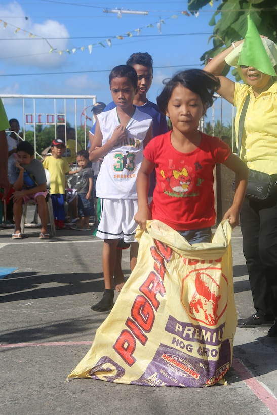 A local child jumps during a sack race April 28 during Exercise Balikatan 2014 in Legazpi City, Albay Province, Philippines. The race was run in conjunction with a day of traditional games that provided the local community and U.S. service members the opportunity to interact and get to know one another on a personal level. Balikatan is an annual bilateral exercise between the Armed Forces of the Philippines and U.S. armed forces designed to strengthen interoperability and country-to-country relations. 