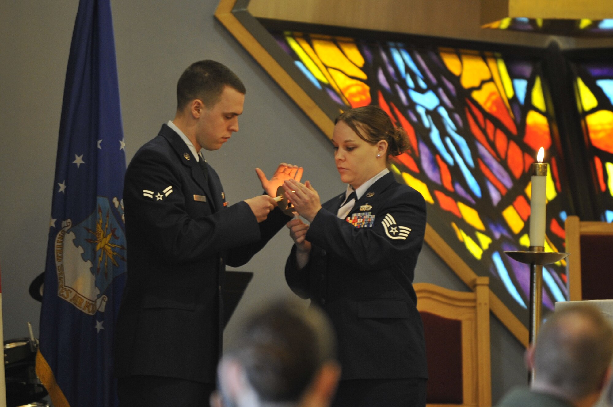 U.S. Air Force Staff Sgt. Jessica Baldwin, 35th Force Support Squadron food service accountant, transfers a flame to U.S. Air Force Airman 1st Class Beau Biggerstaff, 35th Communications Squadron configurations management technician, during the Holocaust Candlelight Vigil at Misawa Air Base, Japan, April 28, 2014. During the vigil, Airmen received a flame from one another and held a moment of silence for those lost during the Holocaust. (U.S. Air Force photo/Airman 1st Class Patrick S. Ciccarone)