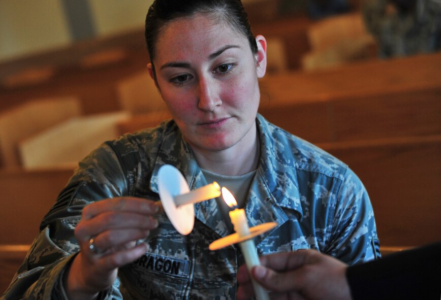 U.S. Air Force Staff Sgt. Amanda Mondragon, 35th Aerospace Medicine Squadron bioenvironmental engineer technician, lights a candle as part of a Holocaust Remembrance Vigil at Misawa Air Base, Japan, April 28, 2014. Airmen lit each other’s candles and held a moment of silence for those killed in the Holocaust massacre. (U.S. Air Force photo/Senior Airman Jose L. Hernandez-Domitilo)