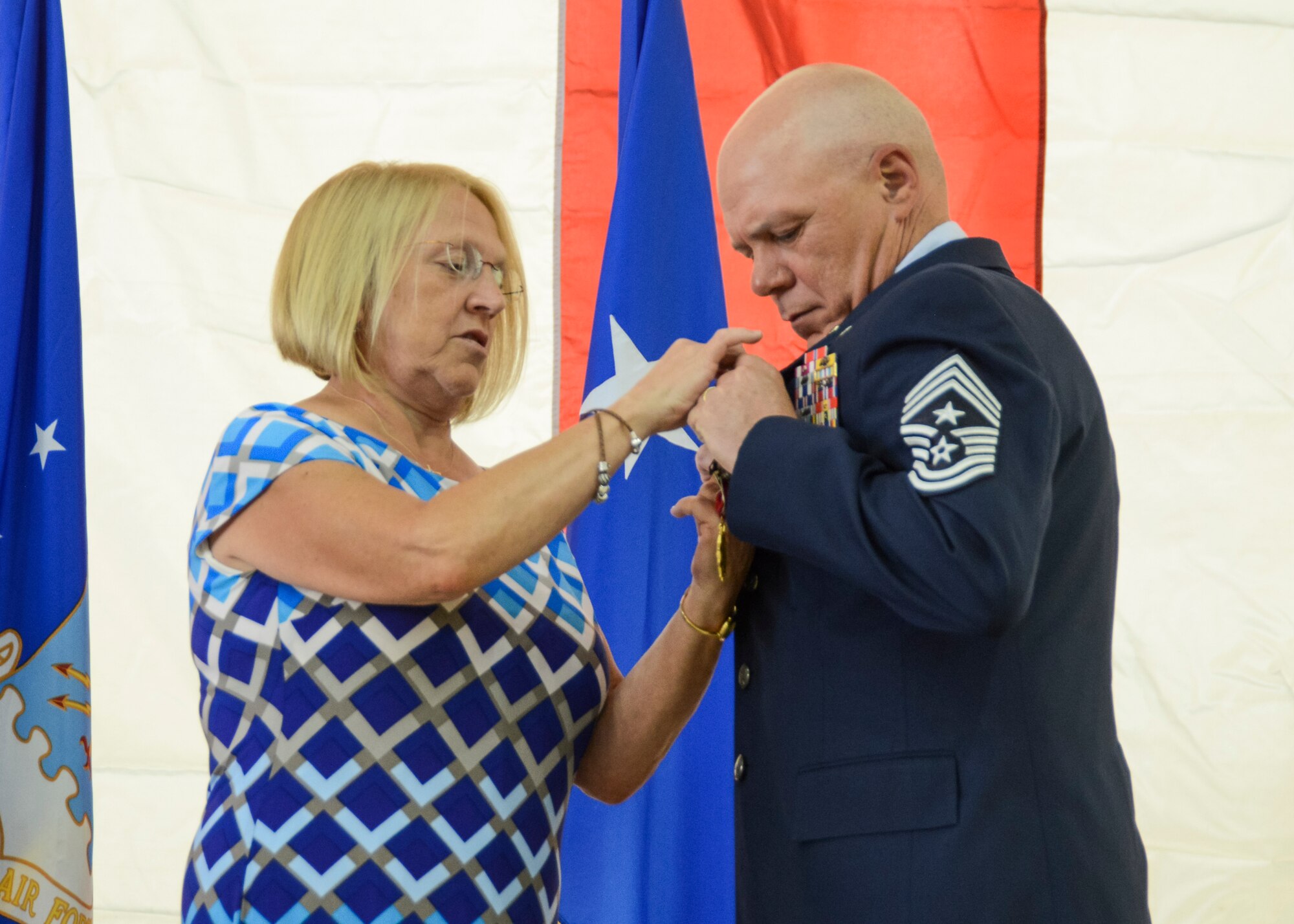Chief Master Sgt. Christopher McCollor (right), Air Force Test Center command chief, receives his retirement pin from his wife, Nancy, April 25. McCollor retires after more than 30 years of service. His final assignment was here at Edwards as the first command chief of the newly created AFTC. (U.S. Air Force photo by Rebecca Amber)