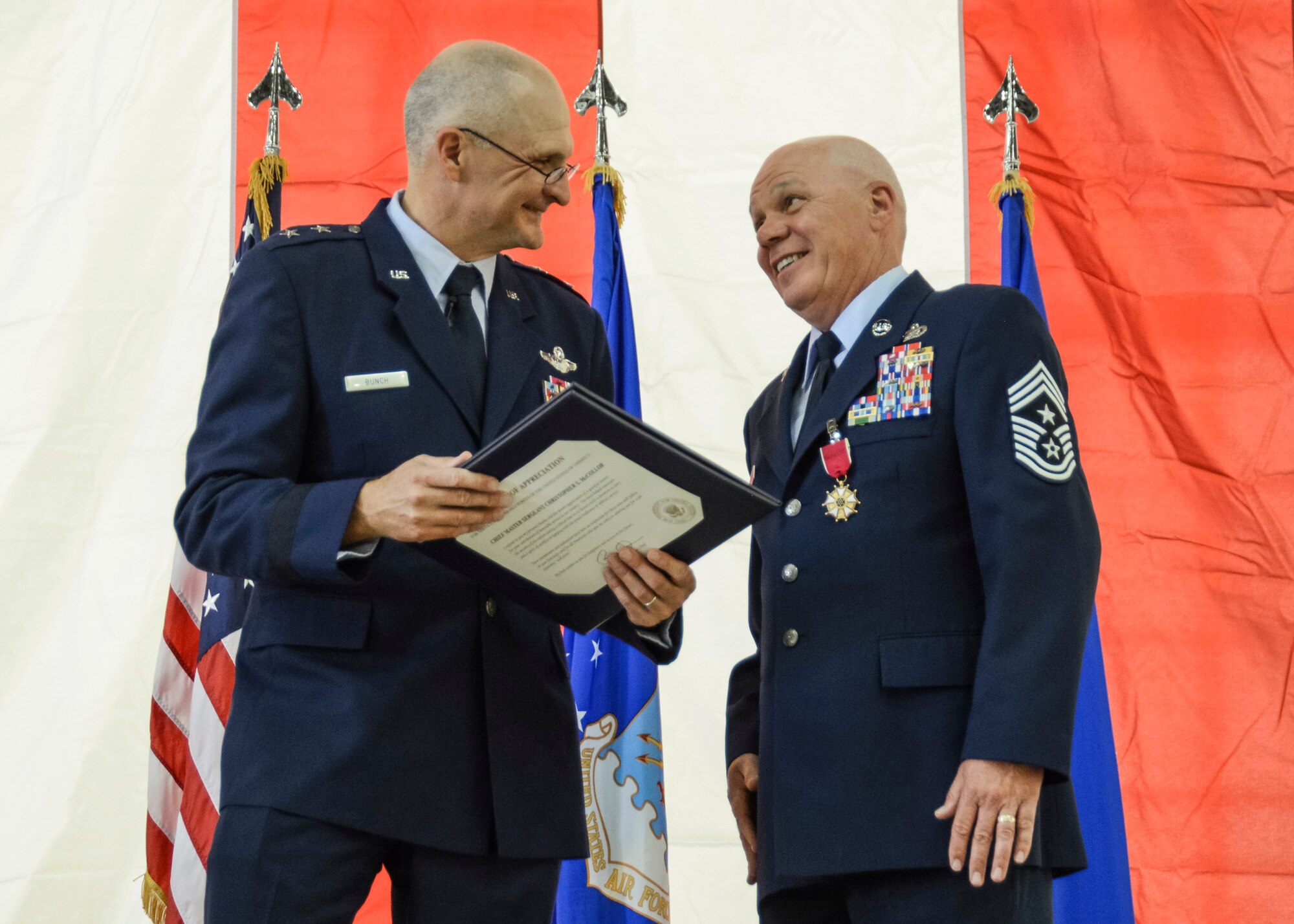 Maj. Gen. Arnold Bunch (left), Air Force Test Center commander, presents one of many certificates of appreciation that Chief Master Sgt. Christopher McCollor received during his retirement ceremony April 25. (U.S. Air Force photo by Rebecca Amber)