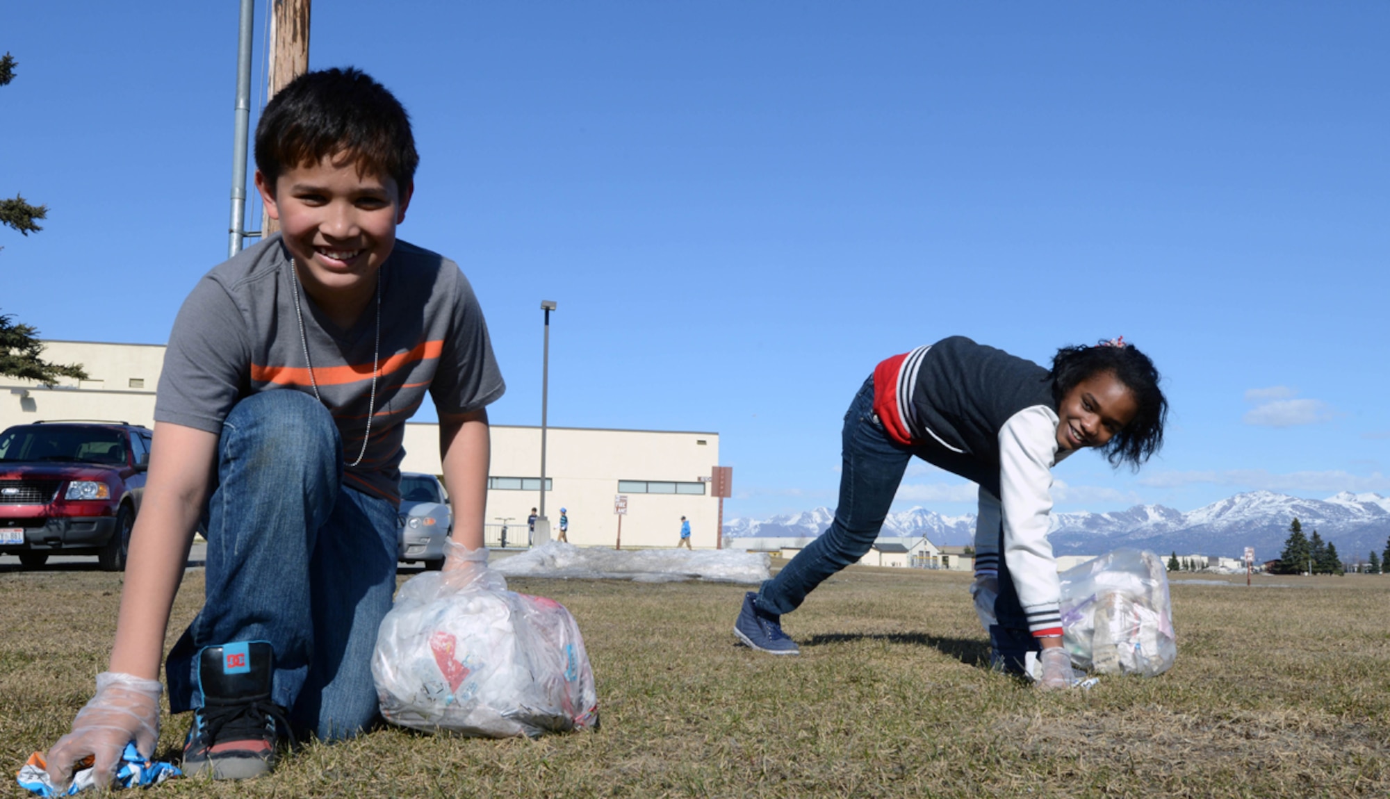 JOINT BASE ELMENDORF-RICHARDSON, Alaska -- JD Dacanay, 11, son of Tech. Sgt. Jumar Dacanay, 525th Aircraft Maintenance Unit, and Nalia Jones, 10, daughter of Air Force Master Sgt. Gregory Jones, 673d Medical Operations Squadron, clean up at the Kennecott Youth Center on Joint Base Elmendorf-Richardson, Alaska, April 21, 2014. The children are members of the Kennecott Youth Center's Torch Club, which promotes leadership and special character development for children in addition to keeping the grounds clean. (U.S. Air Force photo/Airman 1st Class Ty-Rico Lea)